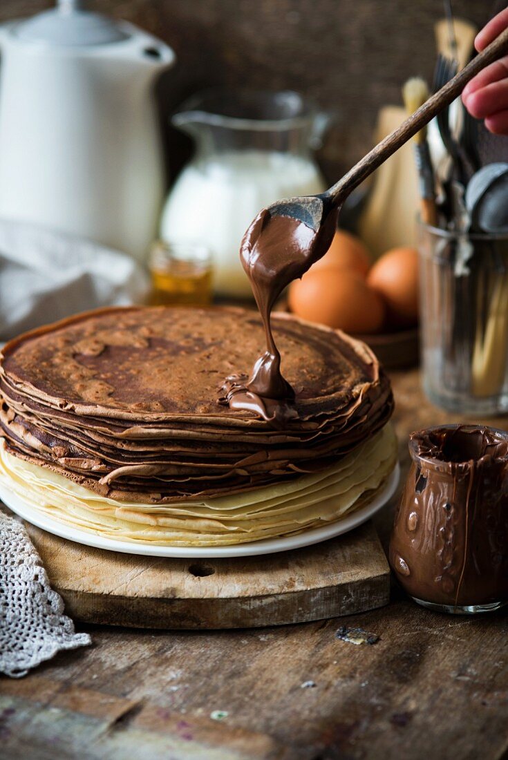 Vanille- und Schokoladencrepes mit Nutella beträufeln