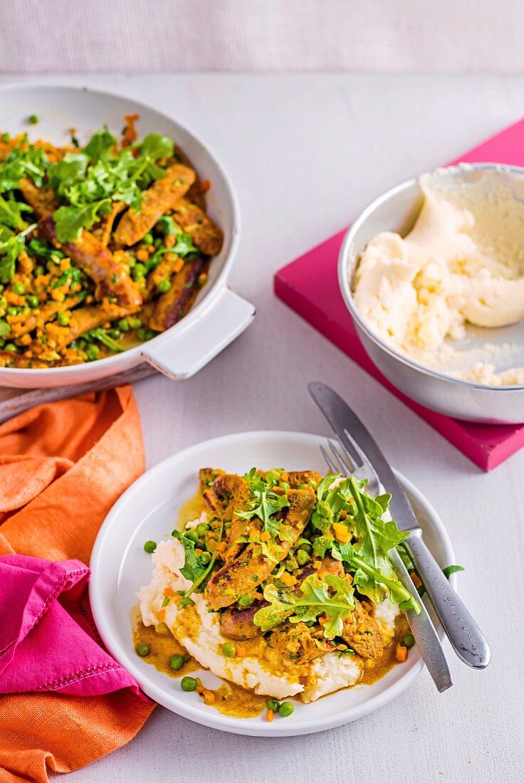 Würstchen mit Curry, Sauerrahm-Kartoffelpüree und Rucola