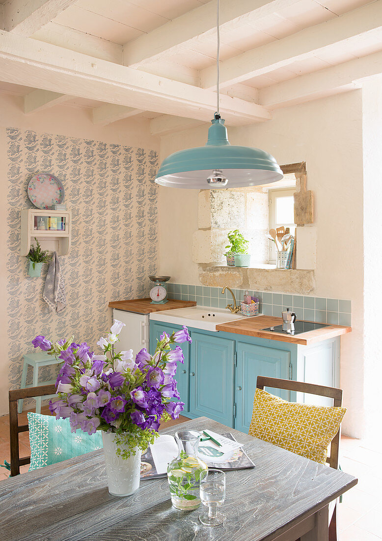 Tisch mit Blumenstrauss in Landhausküche