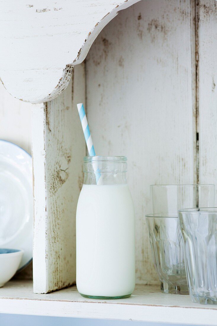 Milch in einer kleinen Flasche mit Strohhalm