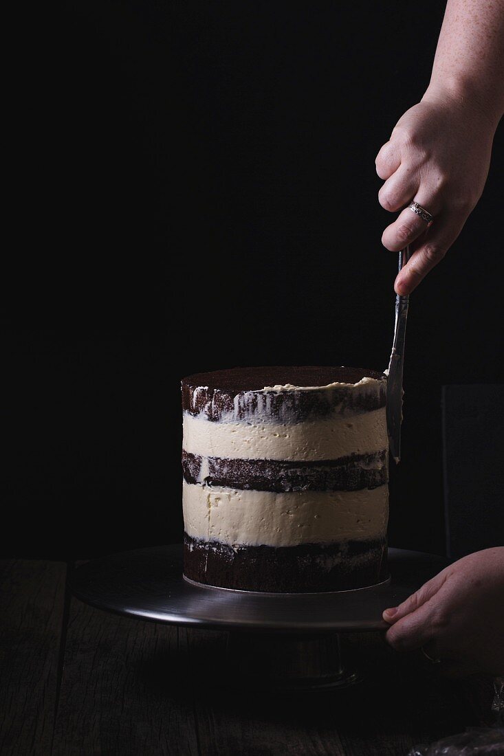 Geschichtete Buttercreme- Hochzeitstorte glasieren