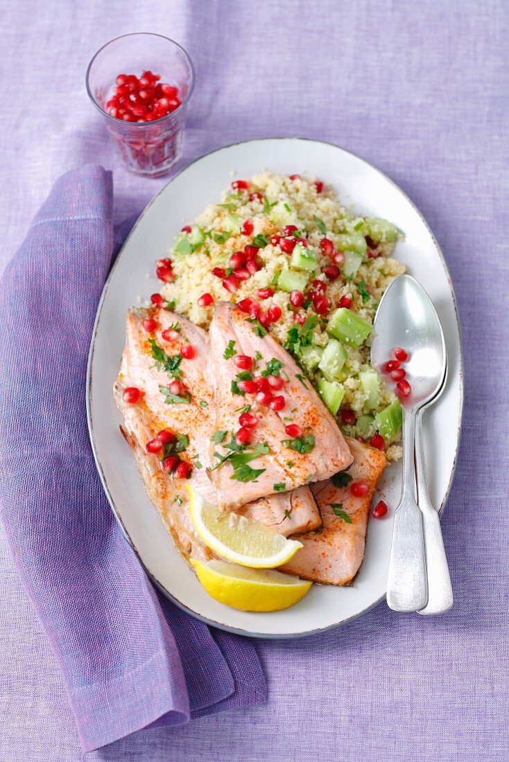 Fried salmon trout with cooscous and cucumber salad and pomegranate seeds