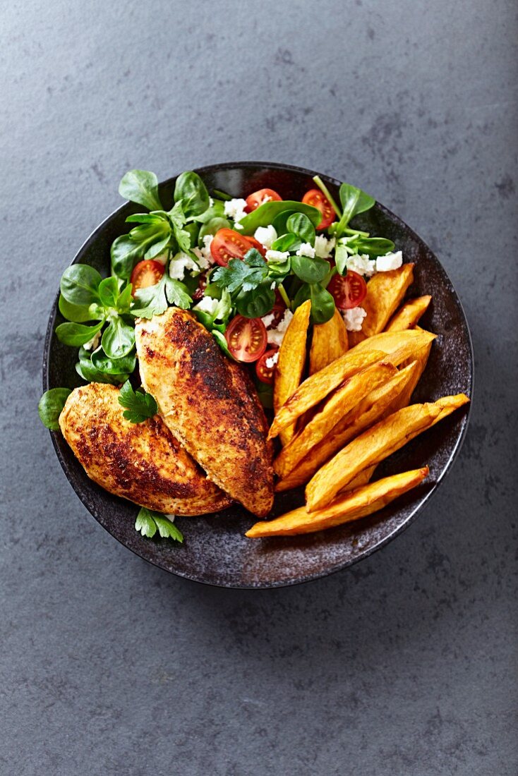 Roasted chicken breast with sweet potato fries and salad