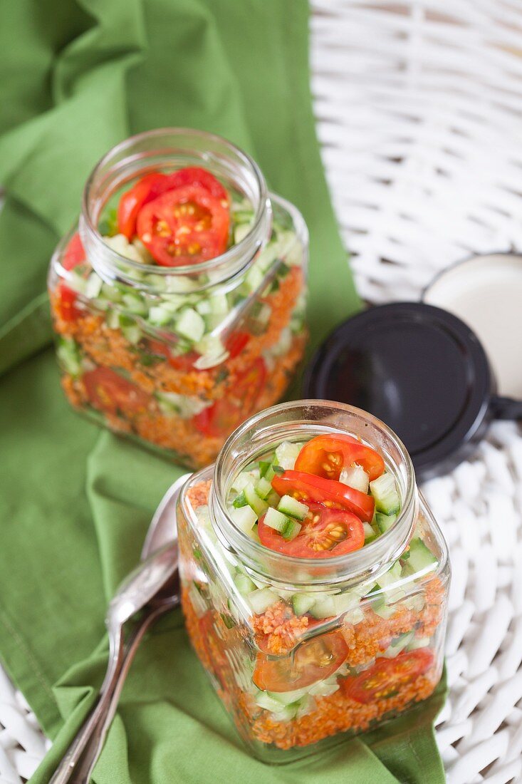 Bulgur wheat salad with pomegranate syrup, onions, cucumber, tomatoes, parsley and mint in a glass jar