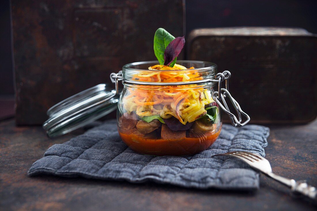 Vegane Tofu-Seitan-Currywurst mit zweierlei Pommesspiralen und Salat im Glas