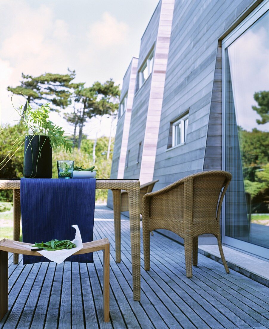 Wicker furniture on wooden terrace adjoining wooden façade