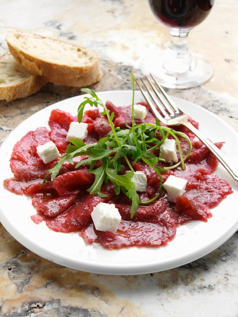 A plate of beef carpaccio with goats cheese