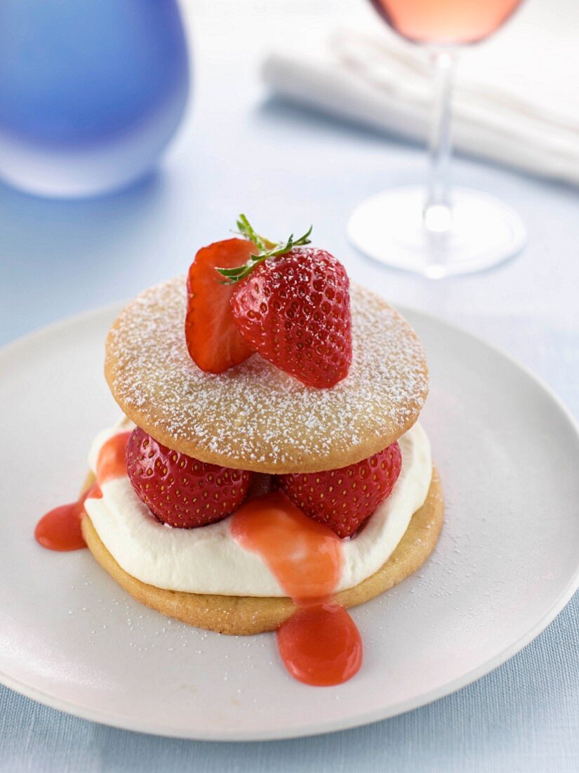 A strawberry sable on a plate in a table setting