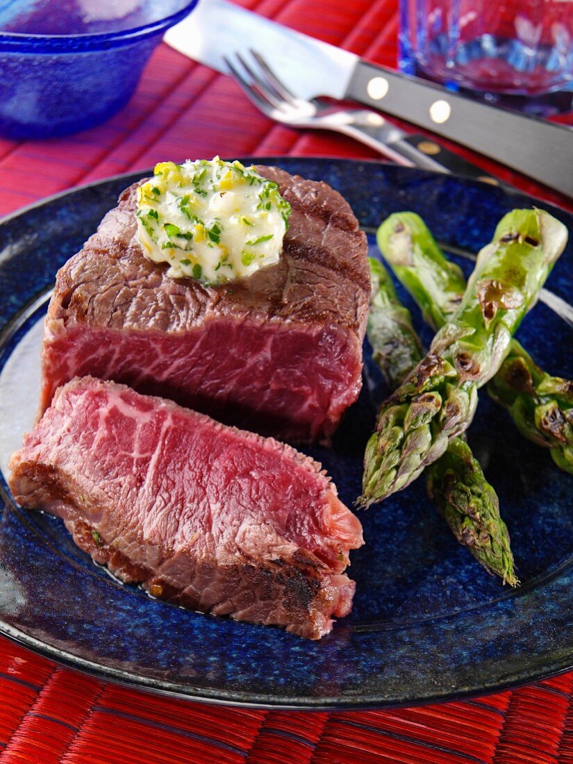 A plate of filet mignon and grilled asparagus