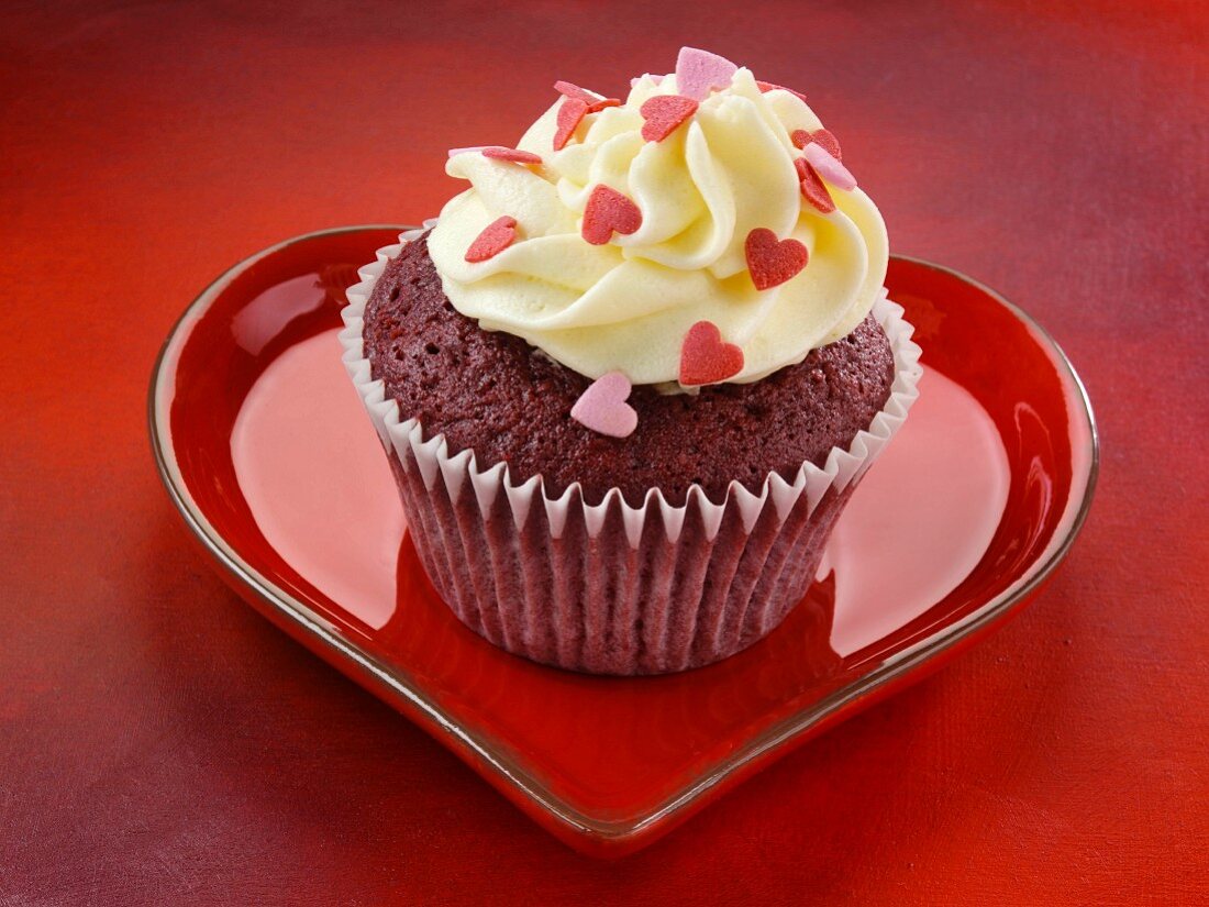 Red Velvet Cupcake auf rotem herzförmigen Teller