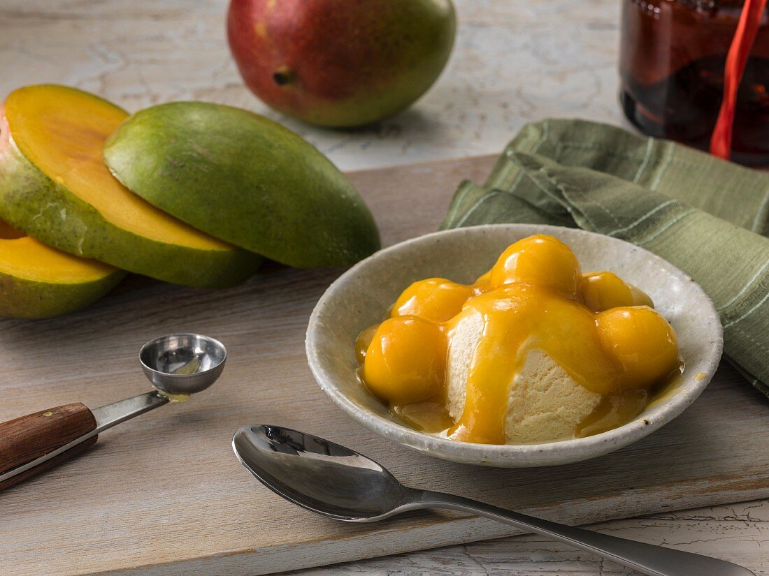 Mango Jubilee Flambe: Mango mit Orangenlikör flambiert auf Vanilleeis