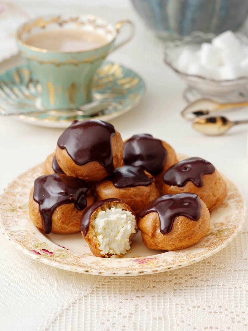 Profiteroles mit Sahnefüllung und Schokoladenglasur zum Kaffee