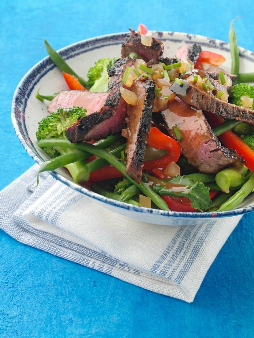 Gegrillte Rinderfiletstreifen auf Gemüsesalat mit Honig-Ingwer-Dressing