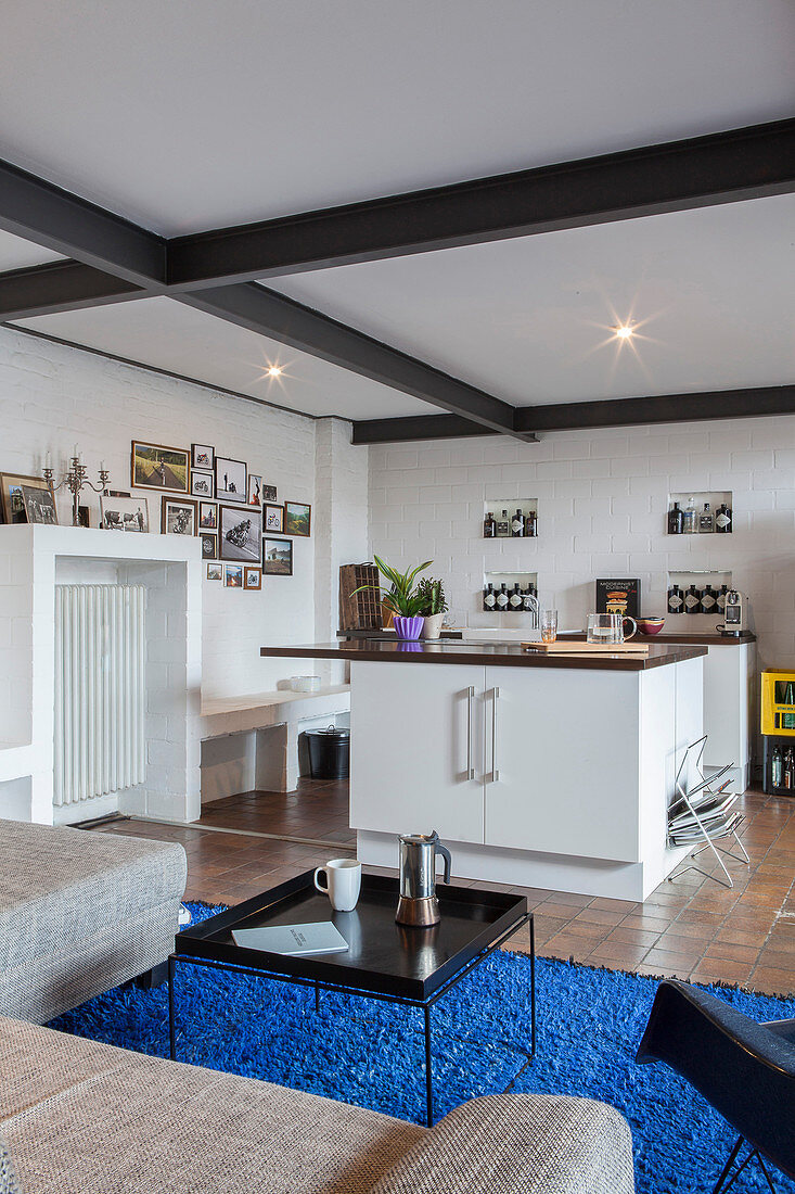 View past sofa into kitchen in open-plan industrial-style interior