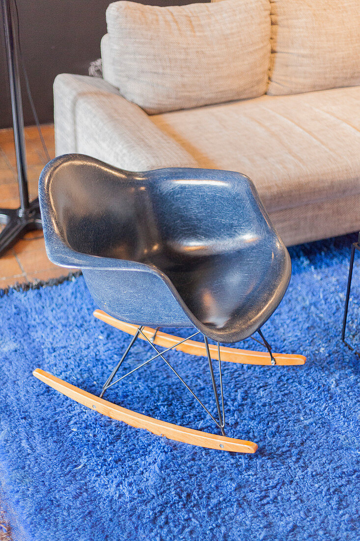 Blue designer rocking chair on bright blue rug
