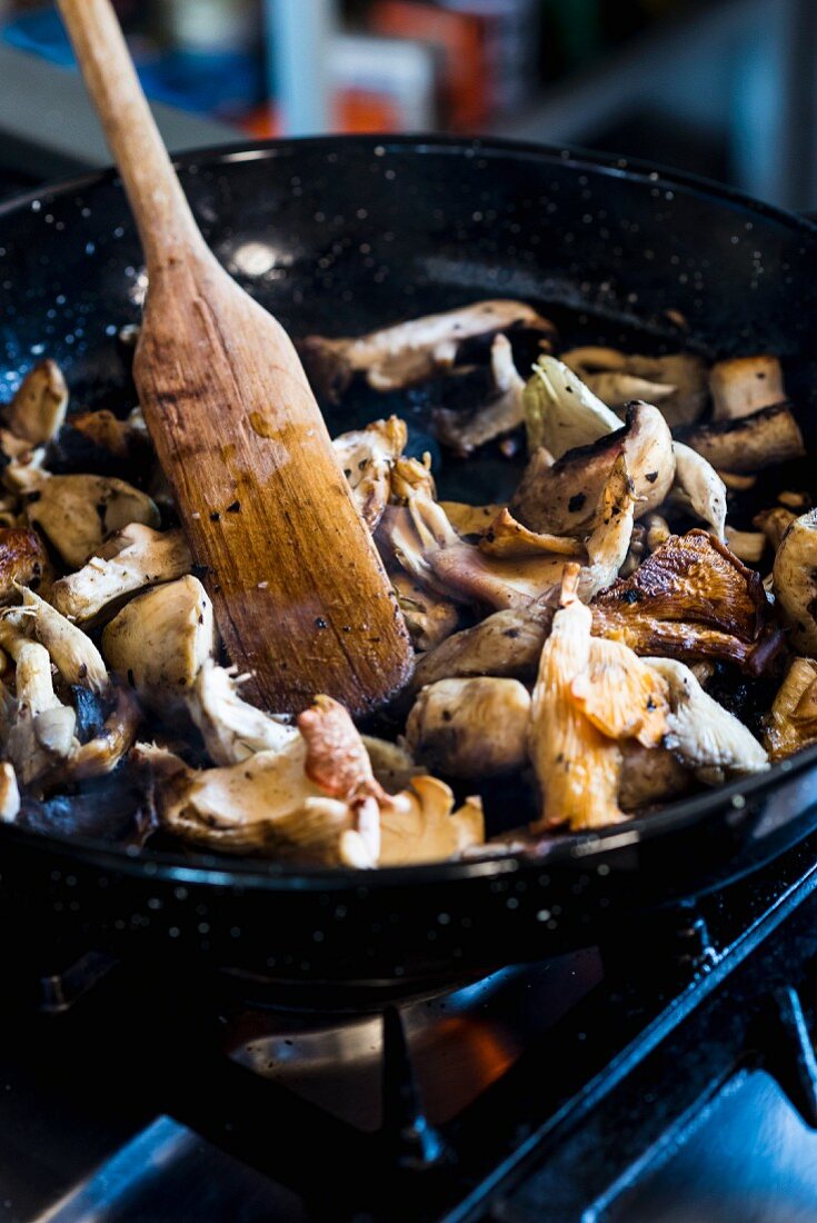 Fried mushrooms in a pan on a gas stove