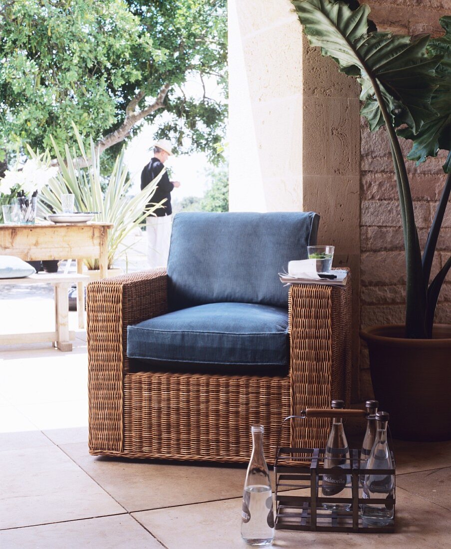 Rattan armchair with cushions on Mediterranean terrace