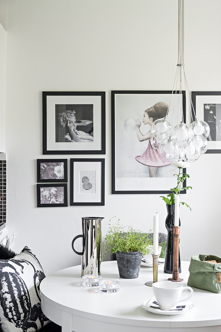 Black-framed pictures above round dining table