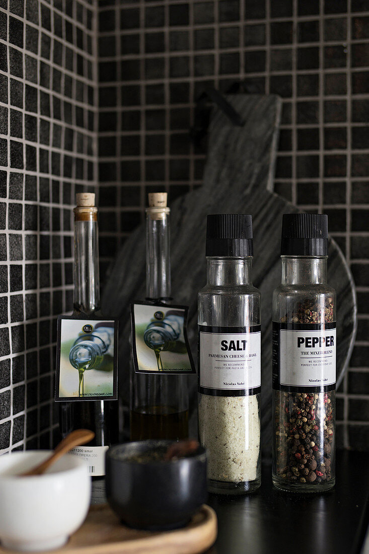Spices against black mosaic-tiled wall