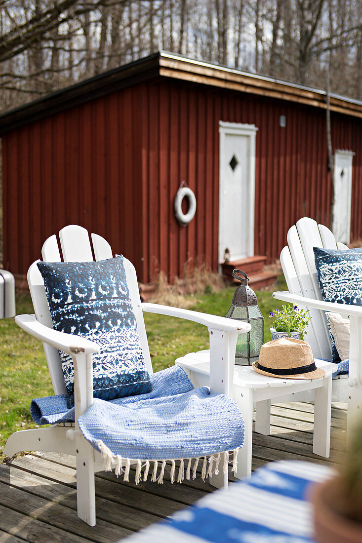 Liegestuhl mit blau-weissen Accessoires auf der Terrasse