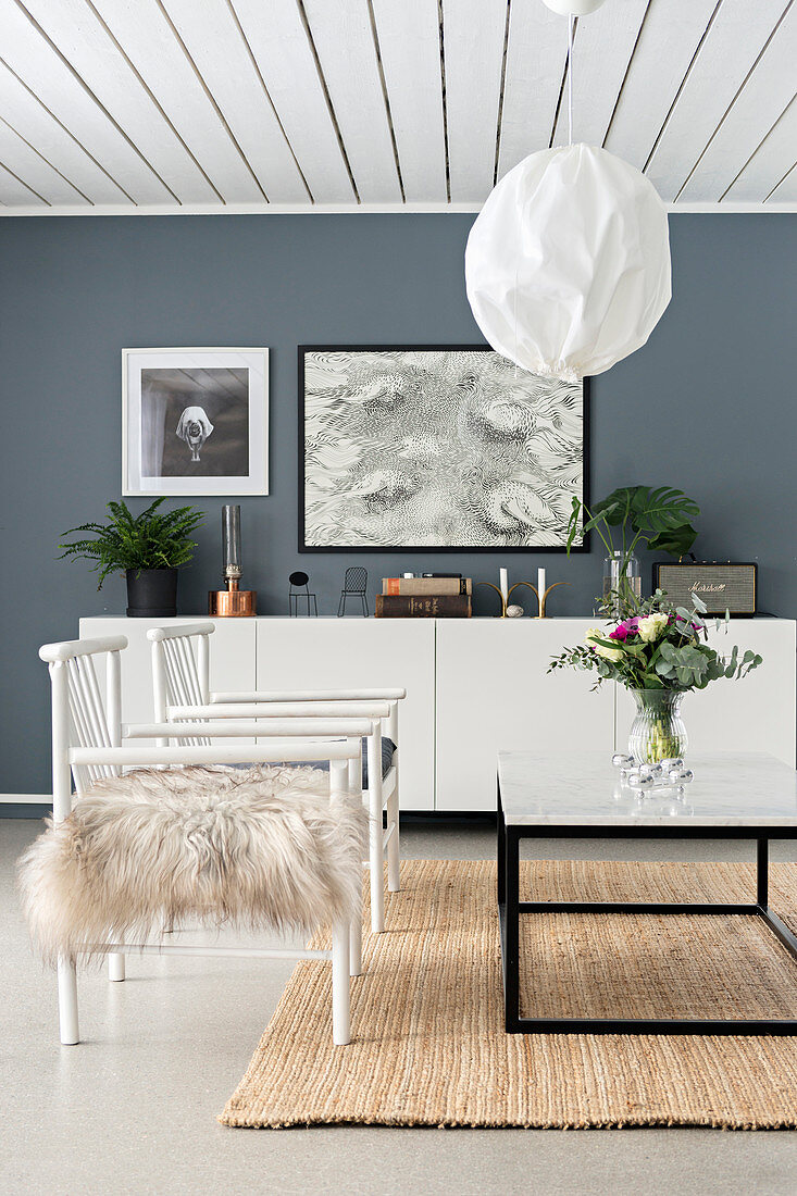 White chairs and coffee table in living room with grey walls