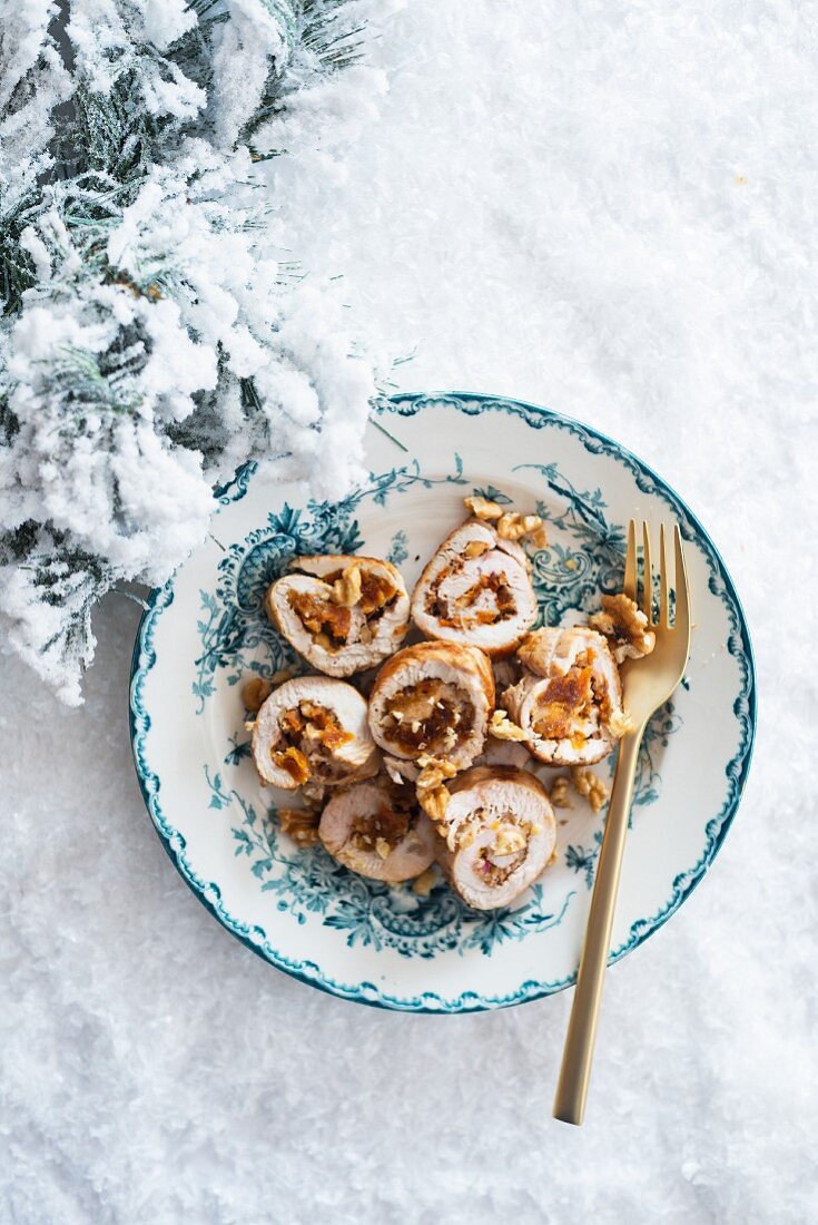 Stuffed turkey breast on a plate in the snow at Christmas