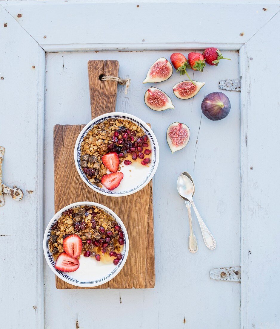 Gesundes Frühstück: Hafermüsli mit Joghurt, Erdbeeren, Feigen und Granatapfel (Aufsicht)