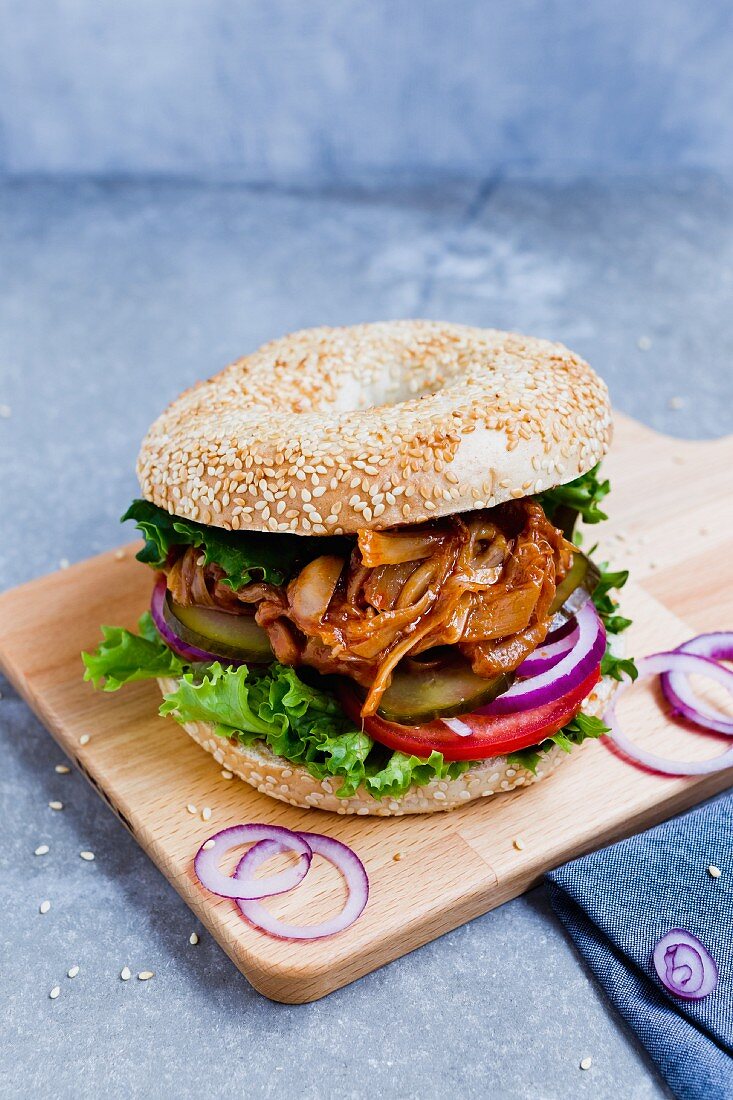 A sesame seed bagel with jackfruit strips