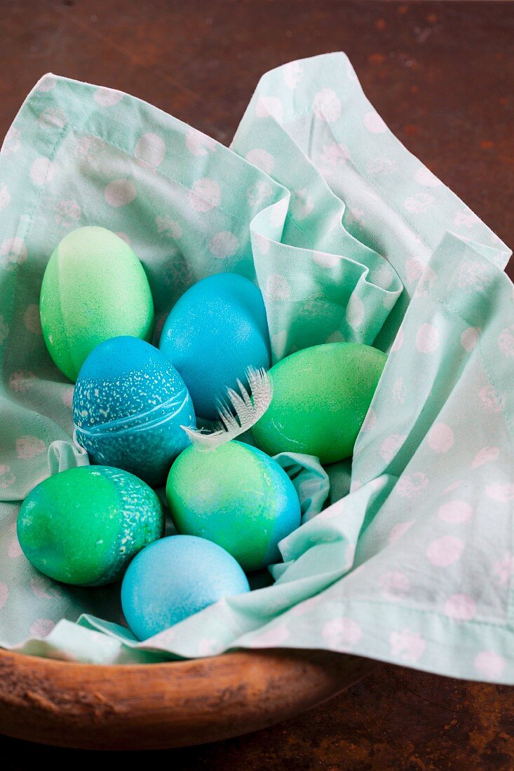 Dyed Easter eggs with batik patterns on a cloth in a basket