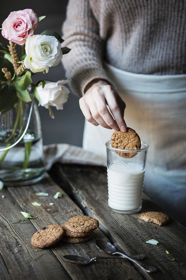 Woman dipping a biscuit in a glass of milk