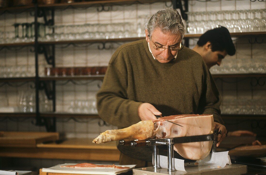 A Man Slicing Ham with a Knife