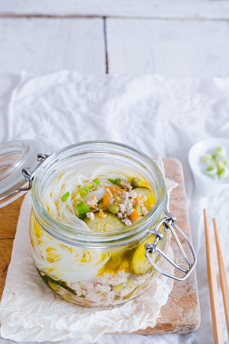 Pork soup with soya noodles in a glass jar (China)