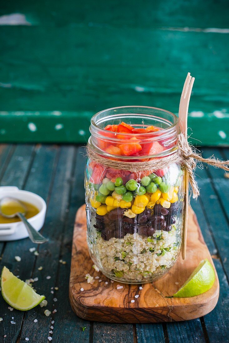 Quinoa salad with vegetables, coriander and lime vinaigrette in a glass jar