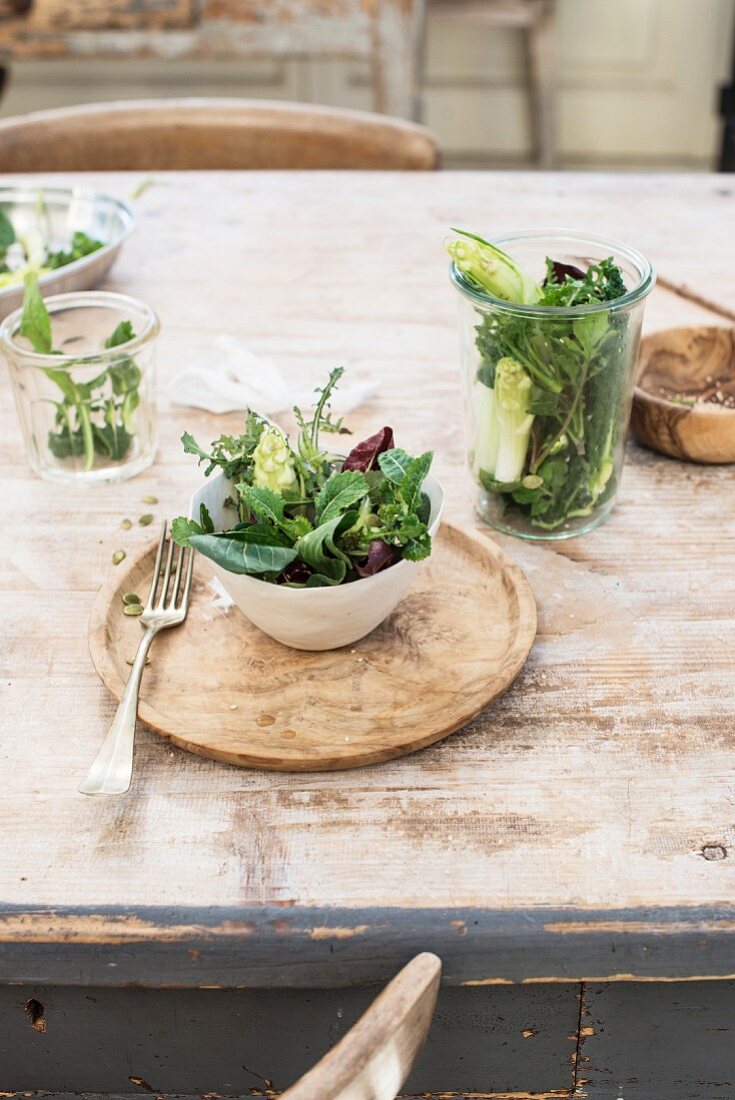 Mixed lettuce leaves in a small bowl and glass