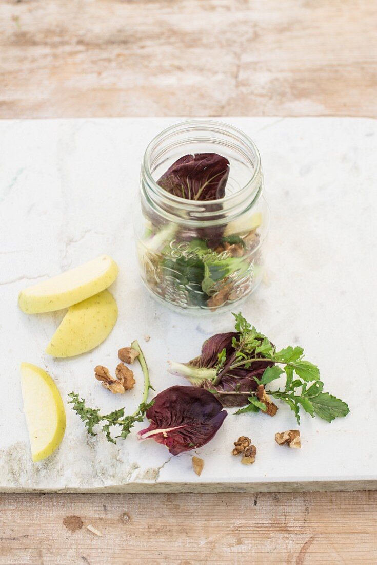 Mixed leaf lettuce with apple in a glass jar