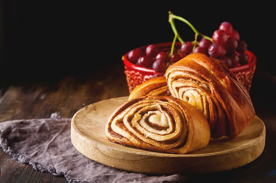 Französisches Brot auf Holztisch vor roten Trauben