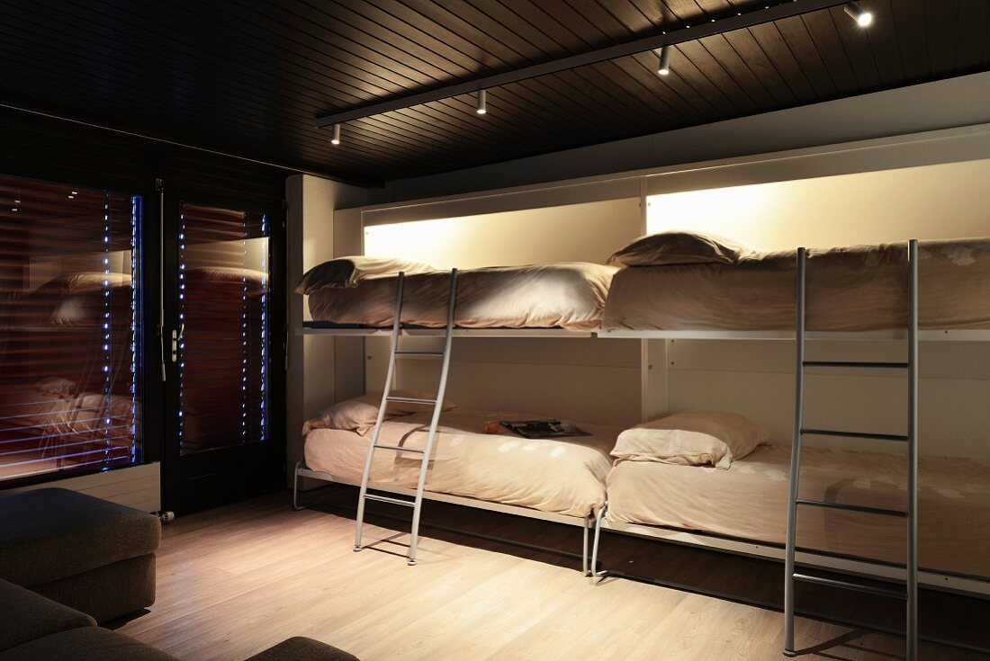 Four beds folded down from wall in multifunctional room