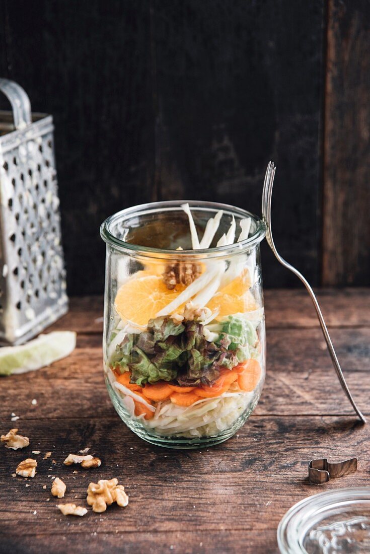 Veganer Salat mit Weisskohl, Karotten, Blattsalat, Fenchel, Orangen und Walnüssen im Glas