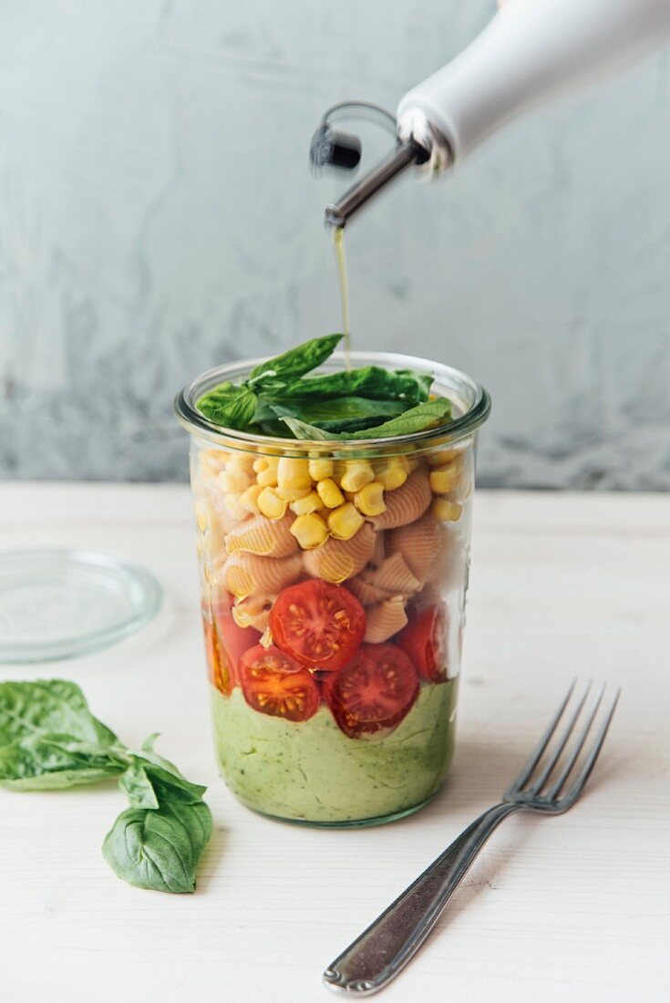 Veganer Nudelsalat im Glas mit Avocadosauce, Tomaten, Buchweizen, Linsen und Mais
