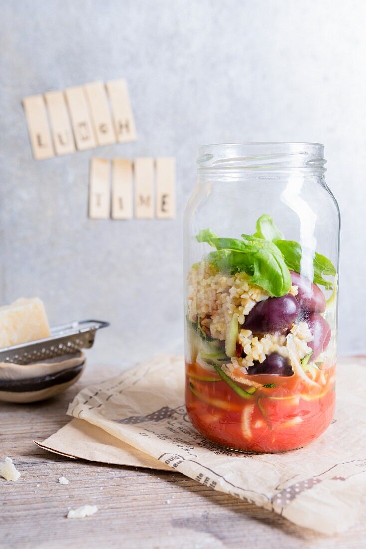Quinoasalat mit Tomaten, Oliven und Basilikum im Glas