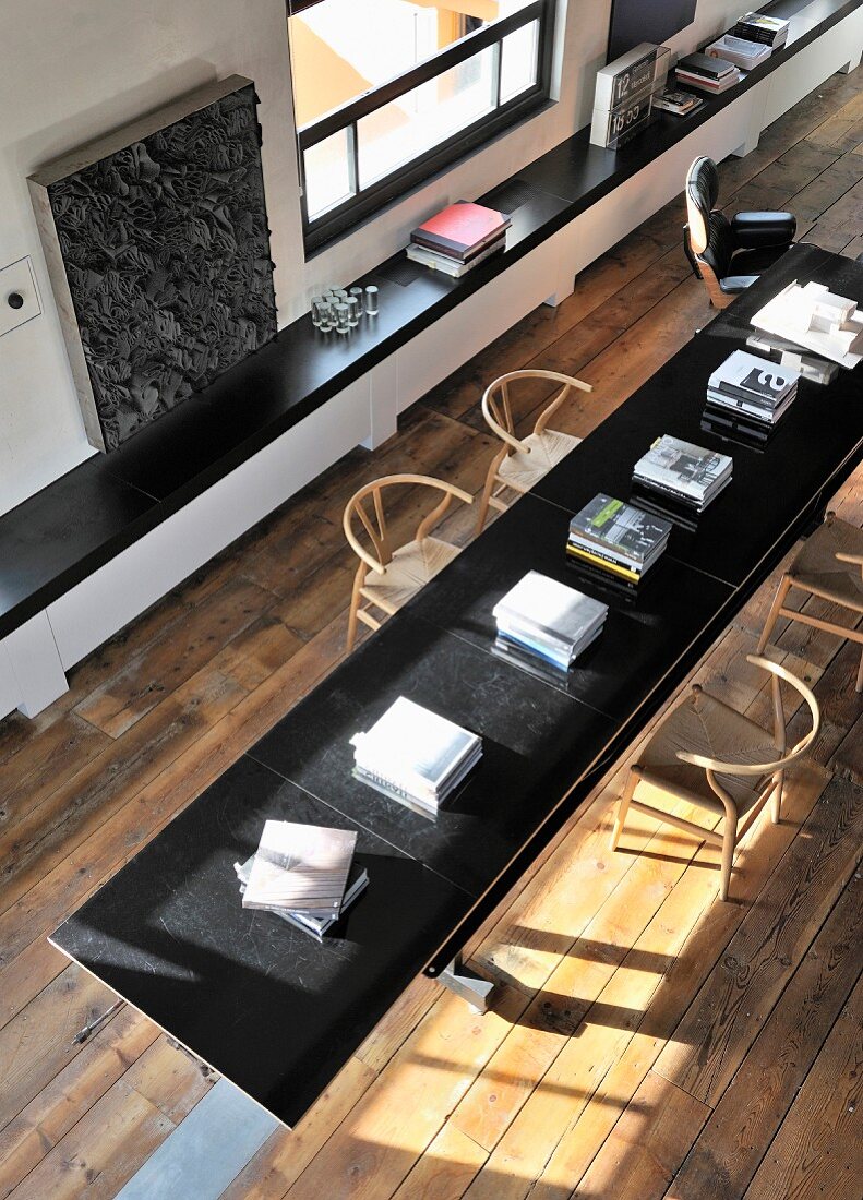 Long black table on restored wooden floor