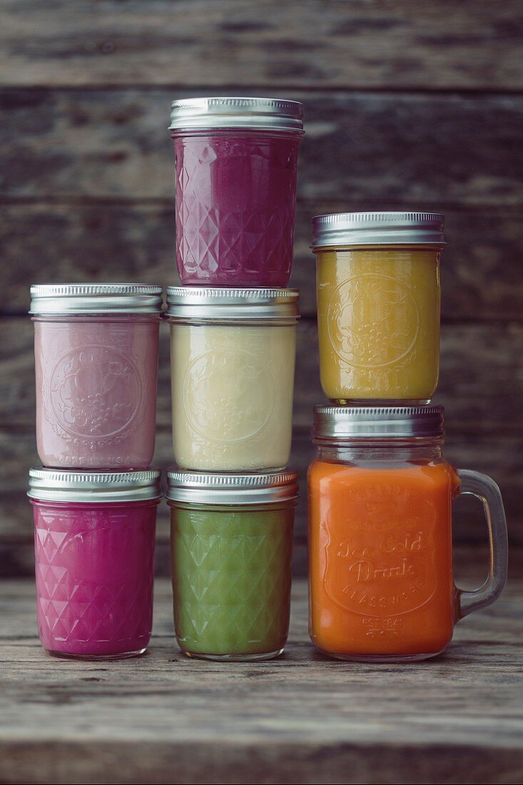 Glass jars of different coloured smoothies