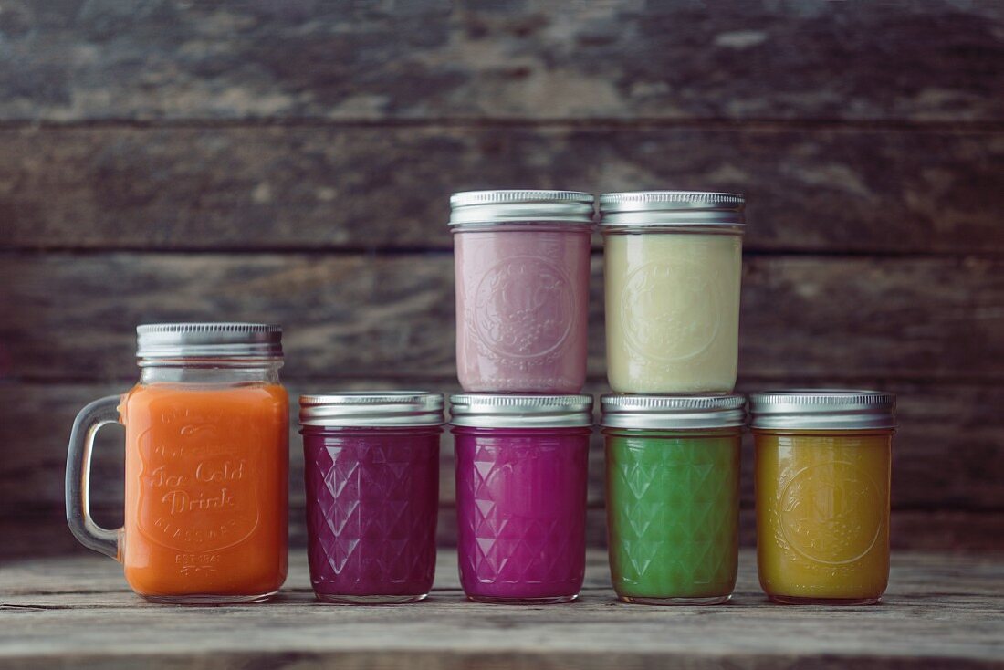 Glass jars of different coloured smoothies