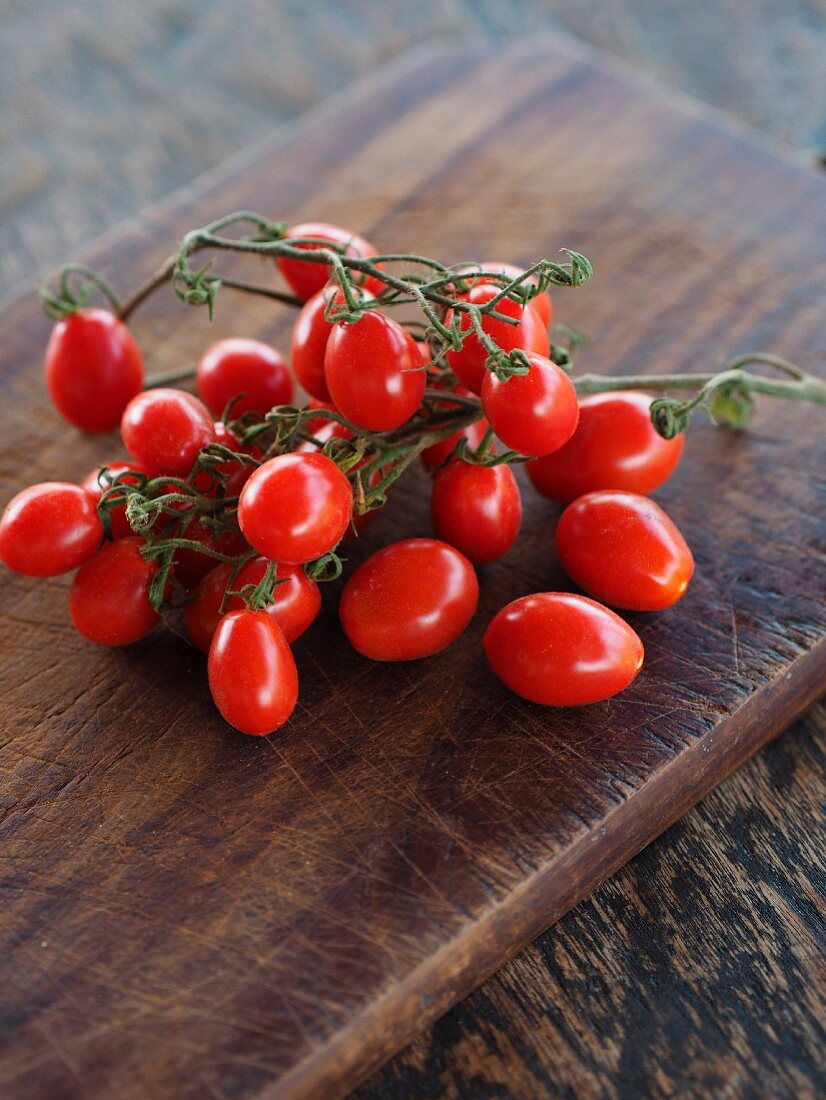 Datterino tomatoes on a wooden board (Pachino, Sicily, Italy)