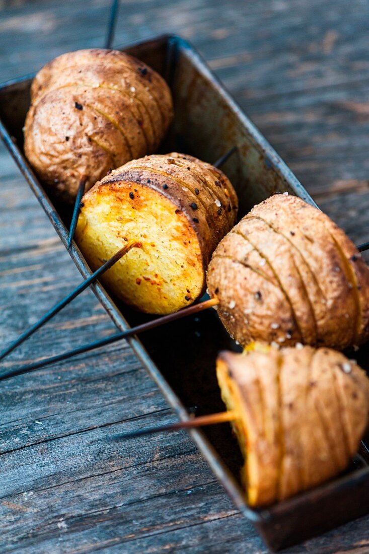 Hasselback potato halves on skewers