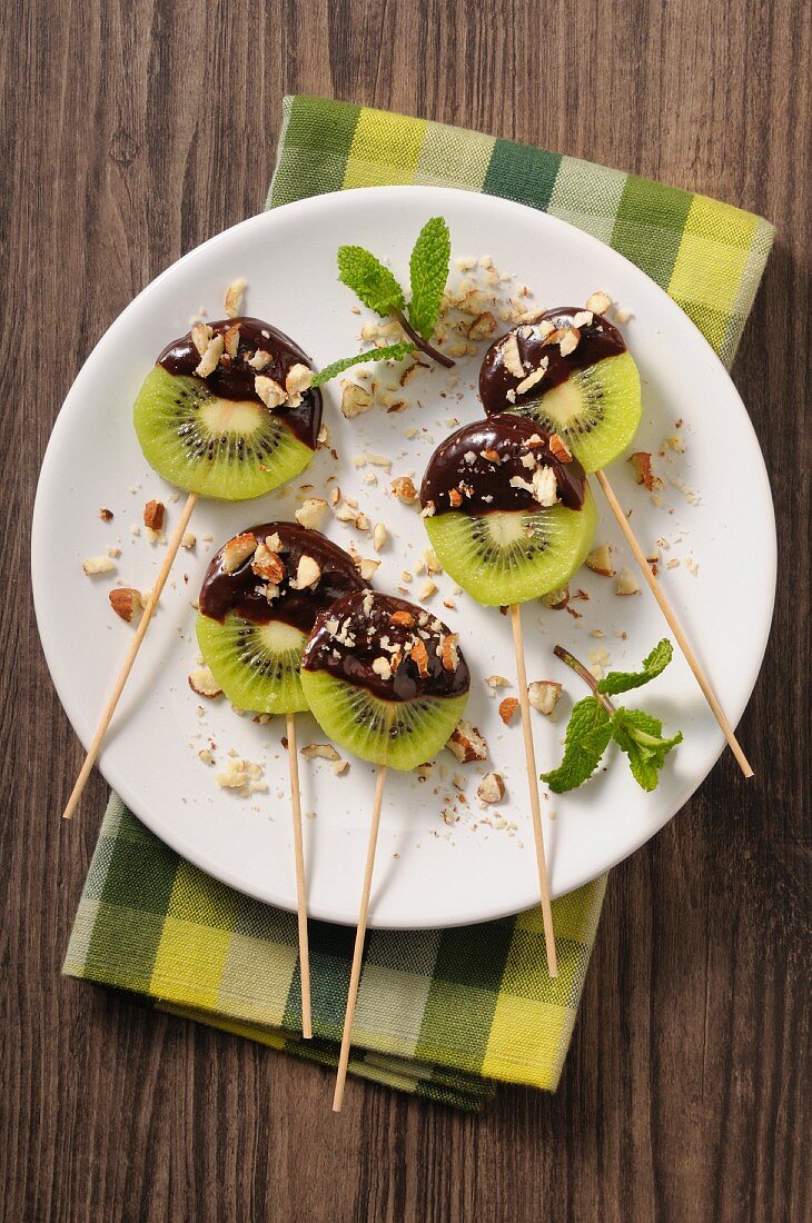 Chocolate and kiwi lollies with chopped nuts