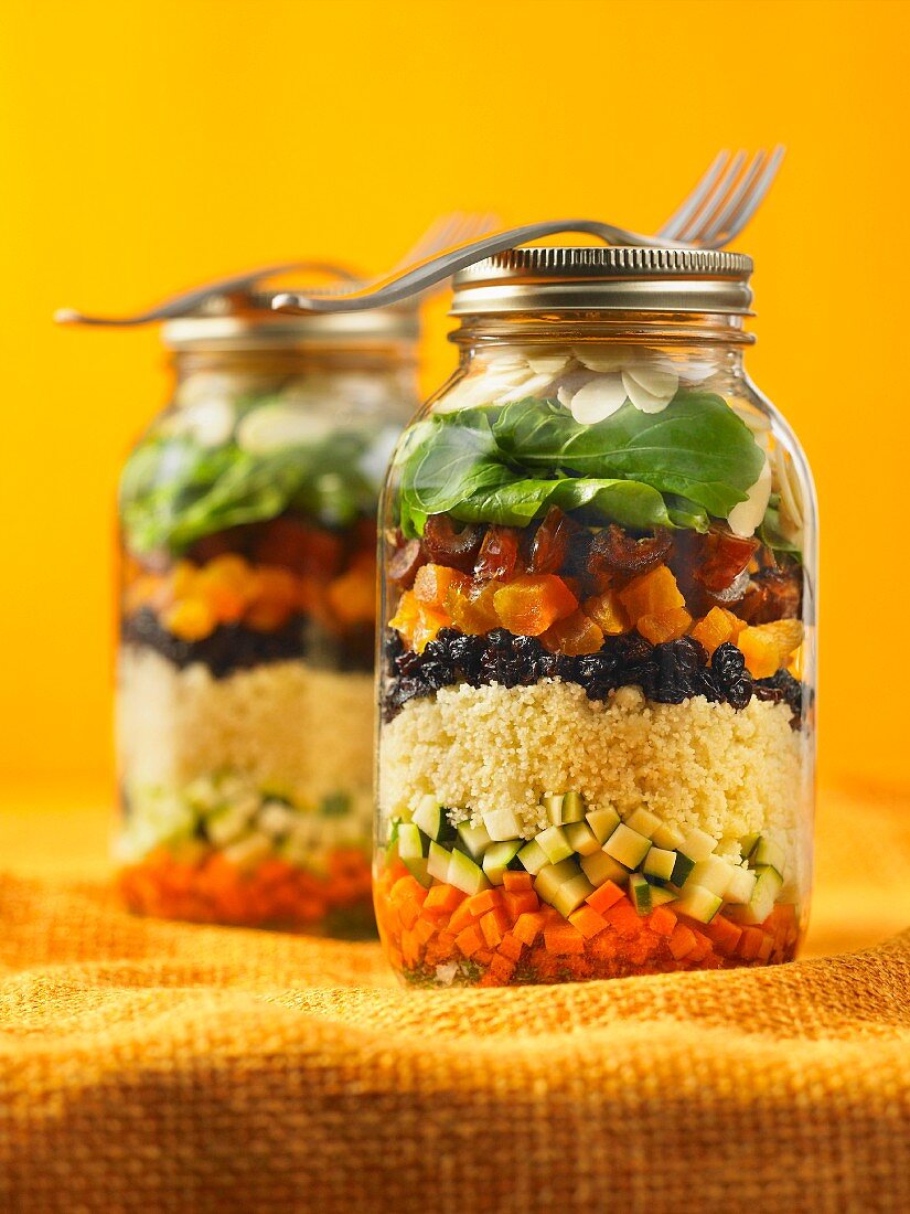 Moroccan couscous salad with vegetables and raisins in glass jars