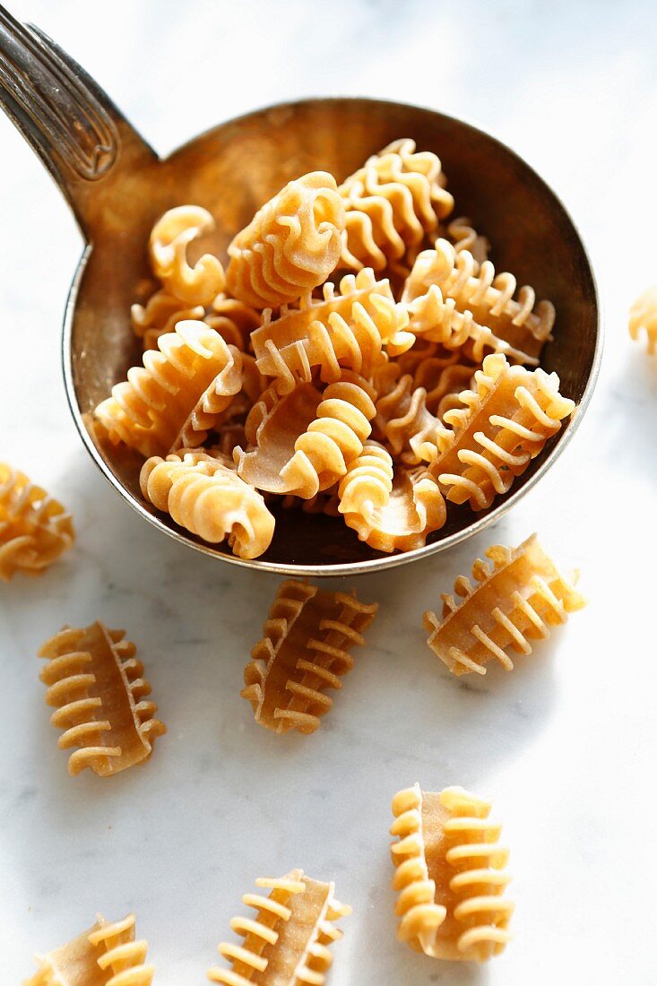 Uncooked armoniche pasta in a ladle