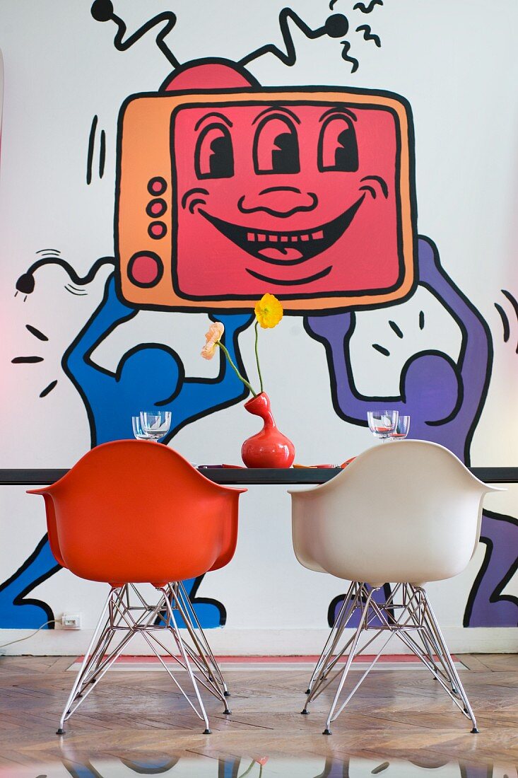 Schalenstühle und Tisch vor Pop Art Gemälde an der Wand