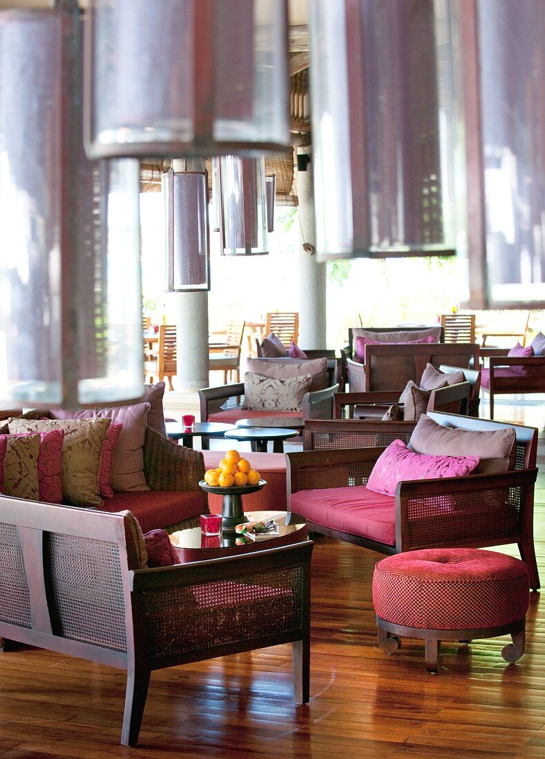 Dark furniture and low-hanging pendant lamps in hotel lounge